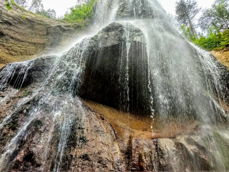 A waterfall cascades down several ledges and onto rocks below.
