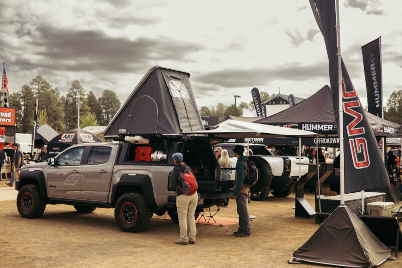 Pickup truck with a roof top tent attached at an outdoor expo