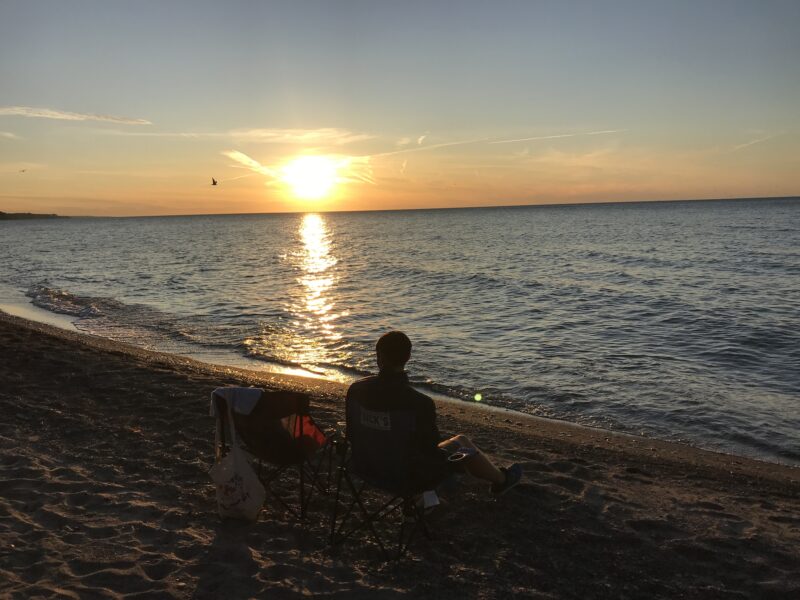A sun sets over the water casting an orange glow.
