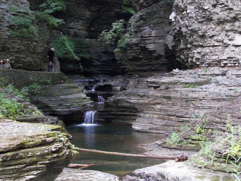 A gentle waterfall cascades down jagged rocks.
