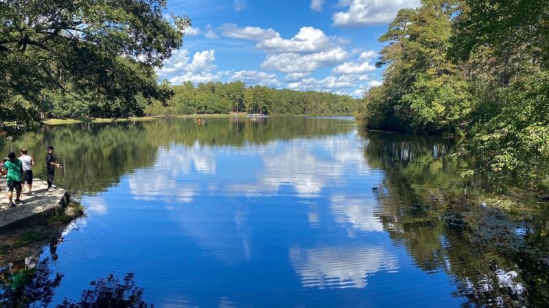 People fish at the edge a scenic blue lake