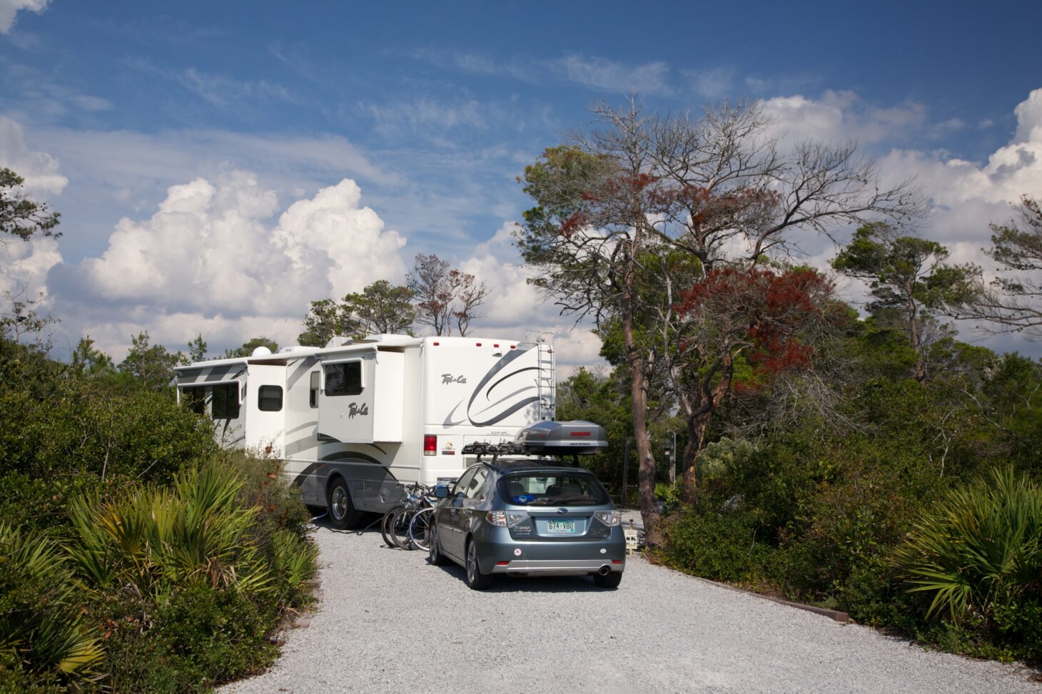 Motorhome parked at a campsite with a towed vehicle behind it