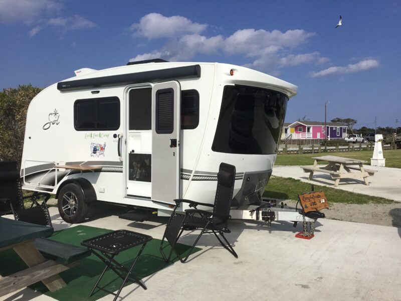 Small travel trailer parked at a campsite