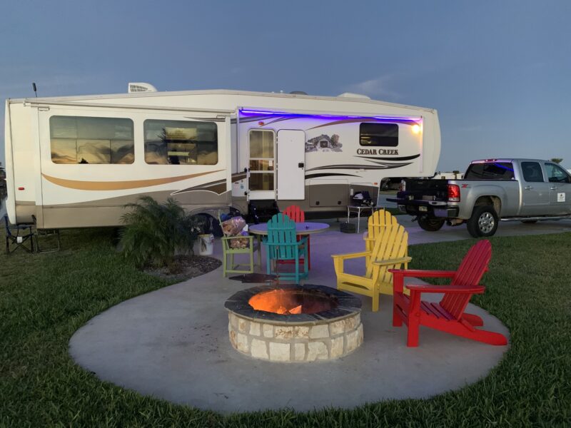 Large fifth wheel RV parked at a paved campsite